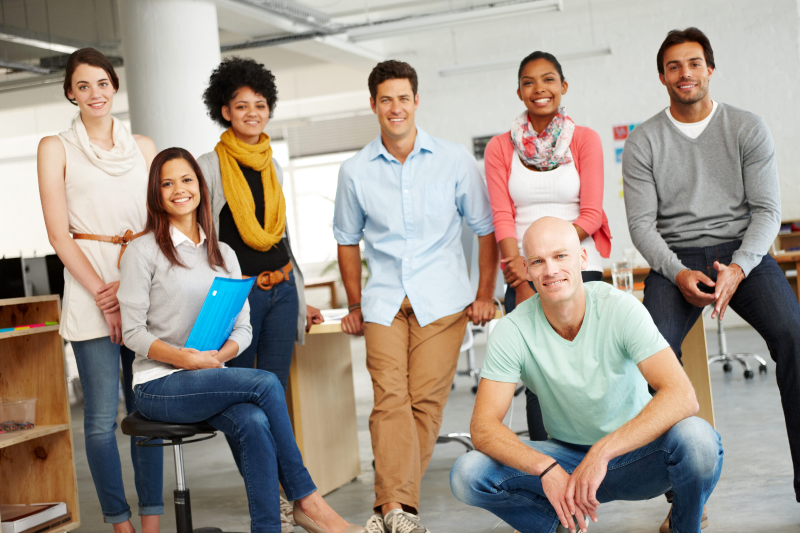 Diverse group of young professionals in a modern office, representing opportunities in entry-level jobs.