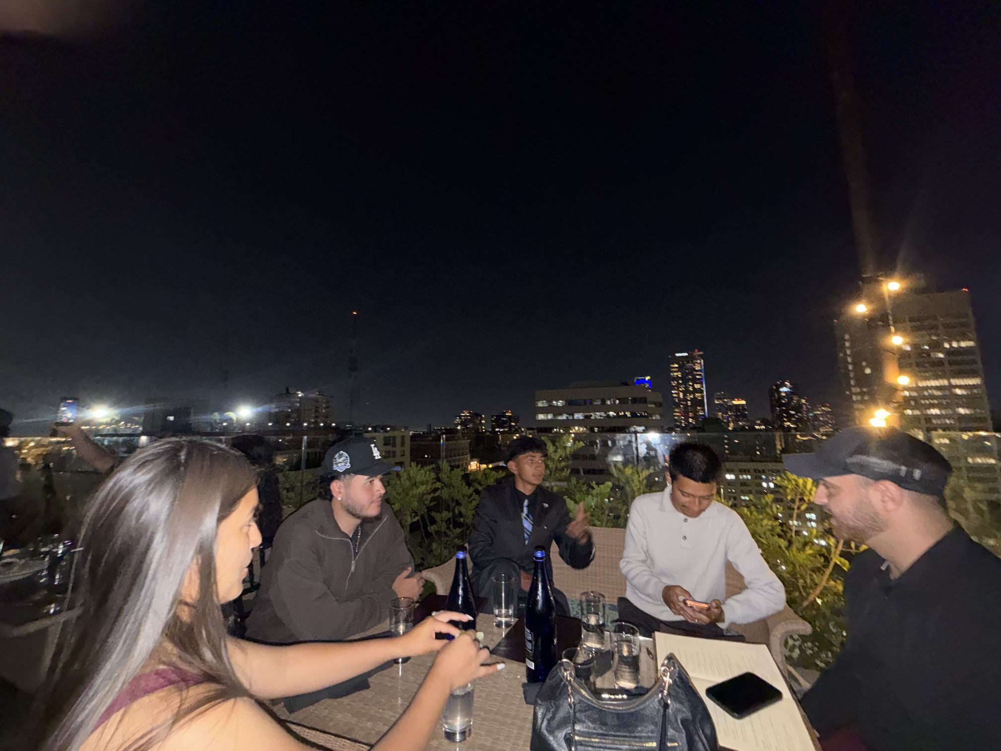 Professionals meeting on a rooftop terrace during an evening networking session
